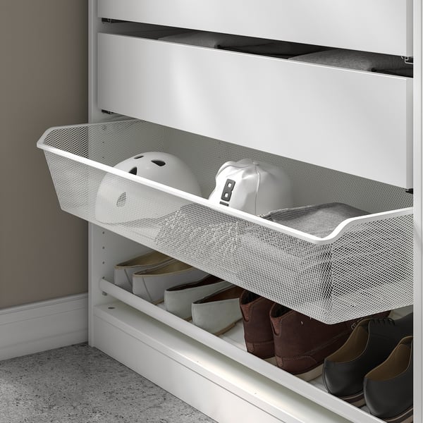 White mesh basket drawer with clothes and helmets, part of a wardrobe.