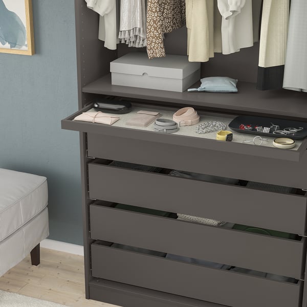 Dark wooden dresser with multiple drawers, a pull-out tray, and an open shelf holding several folded clothes and accessories.