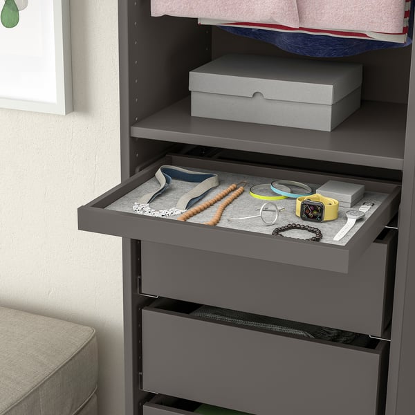 Grey wardrobes pull-out tray displays jewellery, including necklaces, bracelets, and a watch, showcasing effective organisation and easy access.