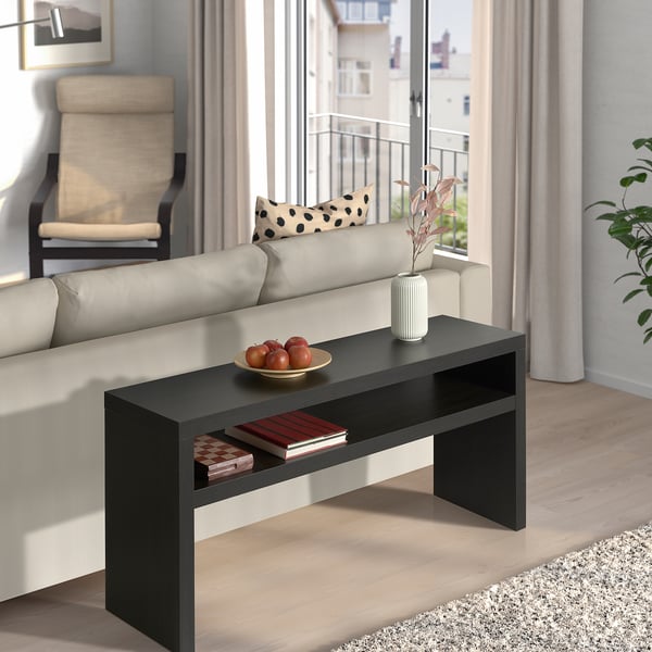 Modern living room with bLACK LACK console table, fruit bowl, book, and striped vase. Bright natural light, minimalist decor, and neutral colours.