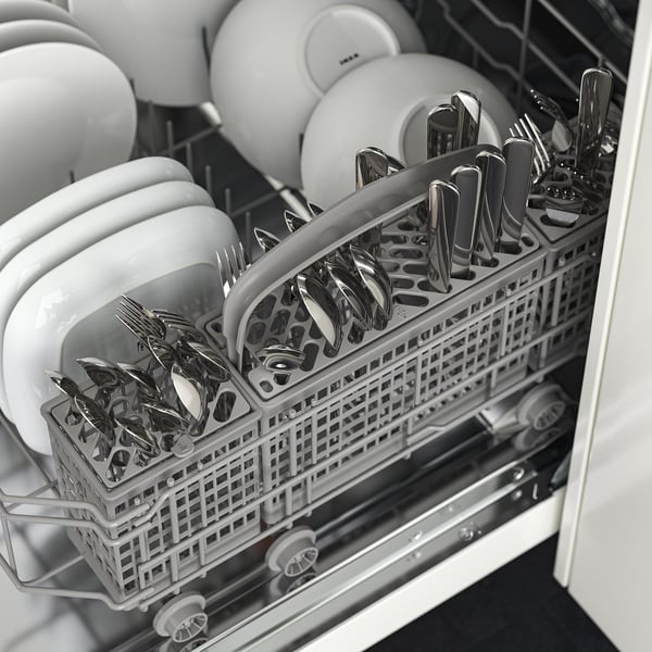 Dishwasher open showing cutlery basket with spoons, forks, and knives, and stacked bowls.