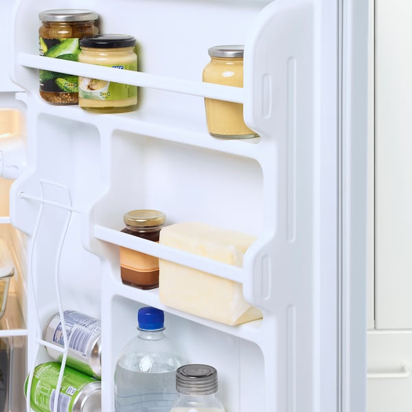 Open fridge with adjustable shelves holding various food items, including jars and a carton, organised for accessible storage.