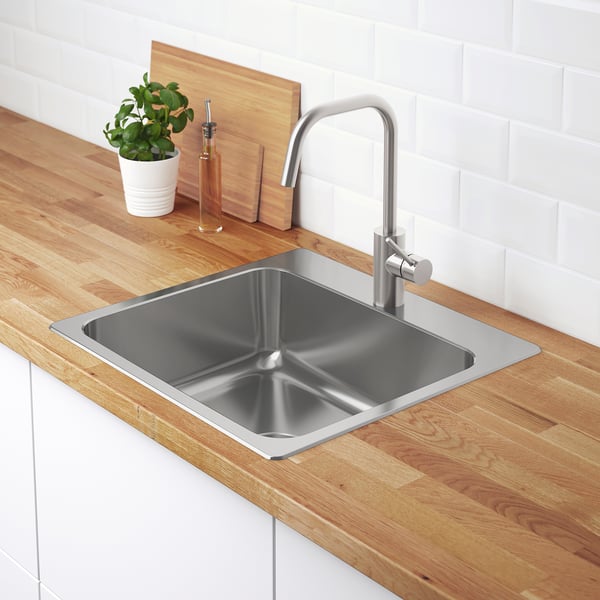 Stainless steel kitchen sink with modern tap, integrated sound-absorbing material for reduced noise, and deep back edge for additional storage.
