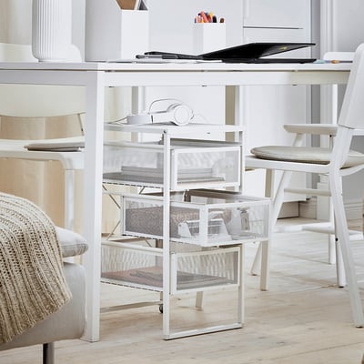 Home office with white LENNART storage drawers. Desk with items, chair, light grey flooring.