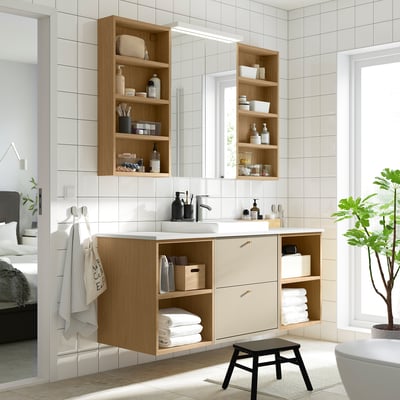 Modern bathroom with wall-mounted LETTAN light oak cabinet, mirrored doors, wood vanity, and black stool.