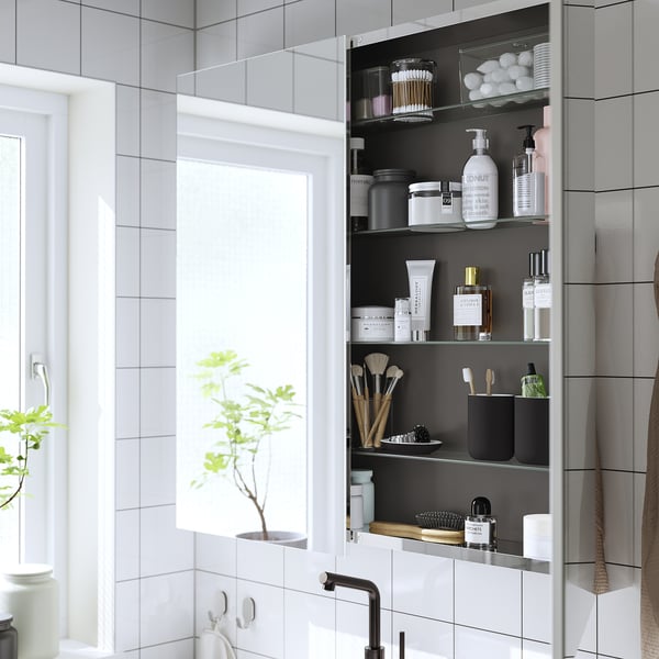 Mirrored wall cabinet with adjustable shelves, storing toiletries and makeup. A shallow design maximises wall space for efficient storage.
