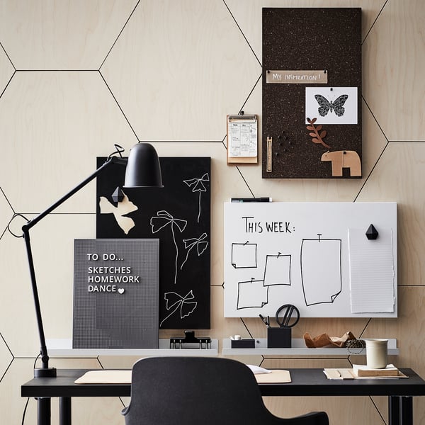 Modern workspace with LINNMON desk, black, large, geometric wall, whiteboard, cork board, lamp, chair, decor.
