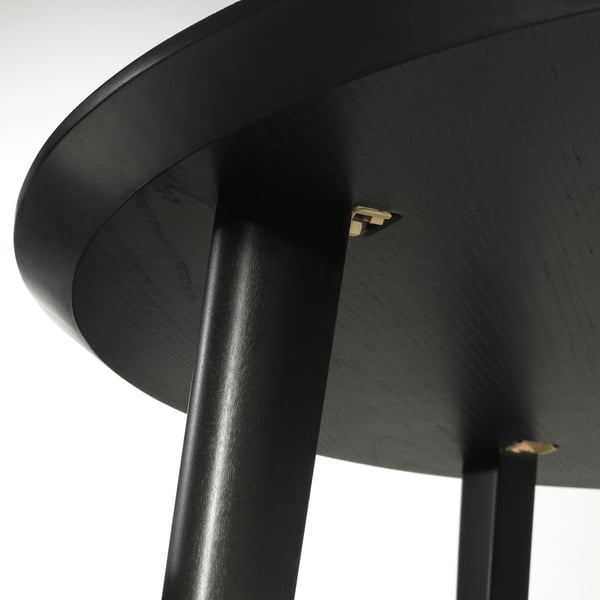Close-up of LISABO table, showcasing smooth dark finish & sturdy wooden legs joinery.