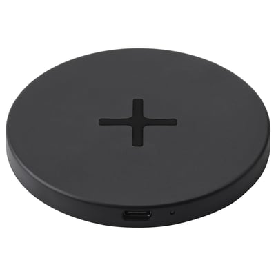 The LIVBOJ wireless charging pad, black, circular, sleek, with a cross design and silicone feet, using usb-c.