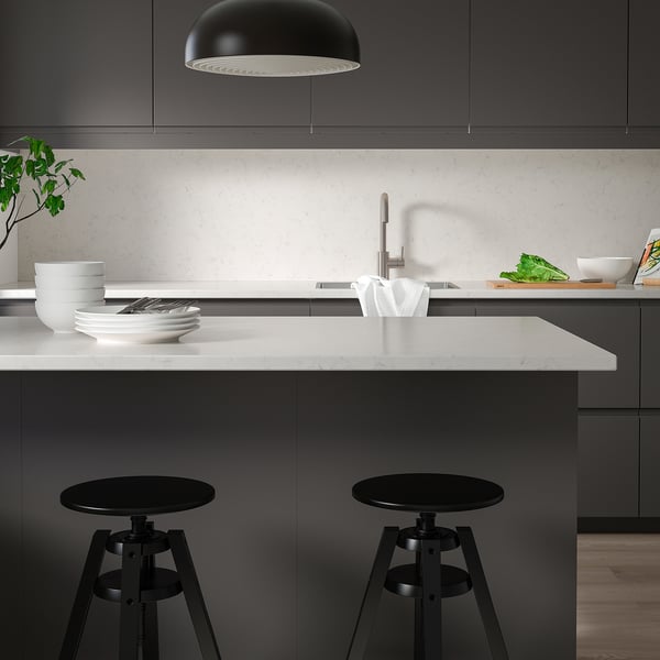 Modern kitchen with black & white decor, grey cabinets, and large countertop.