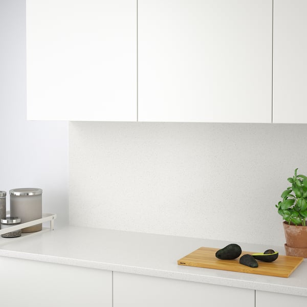 Modern kitchen counter with avocado, plant, and candle holder.