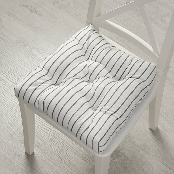 White chair with grey striped cushion on wooden floor.