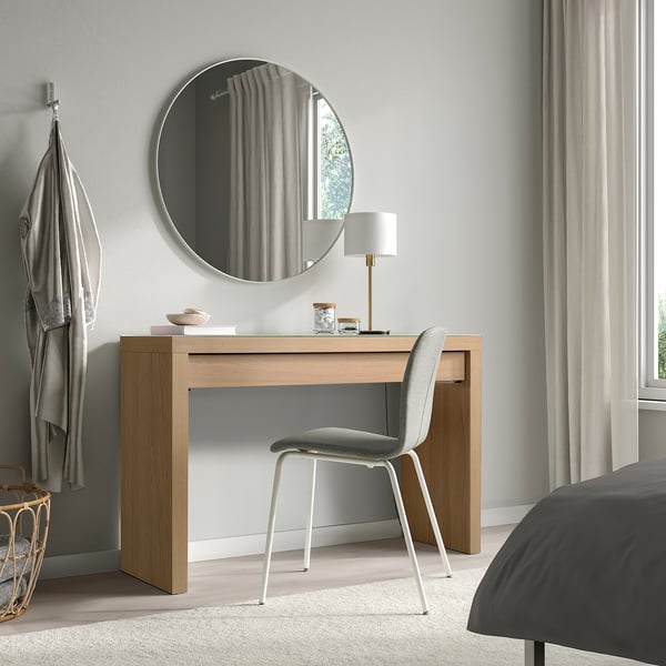 Modern office with MALM desk, chair, lamp, mirror, and bed. Large window with curtains, hanger with garment.