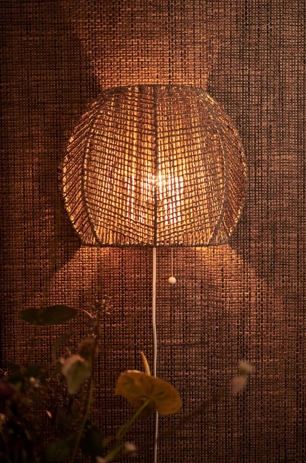 Hand-braided sedge wall lamp, warm light, neutral tones, circular shape, textured design.