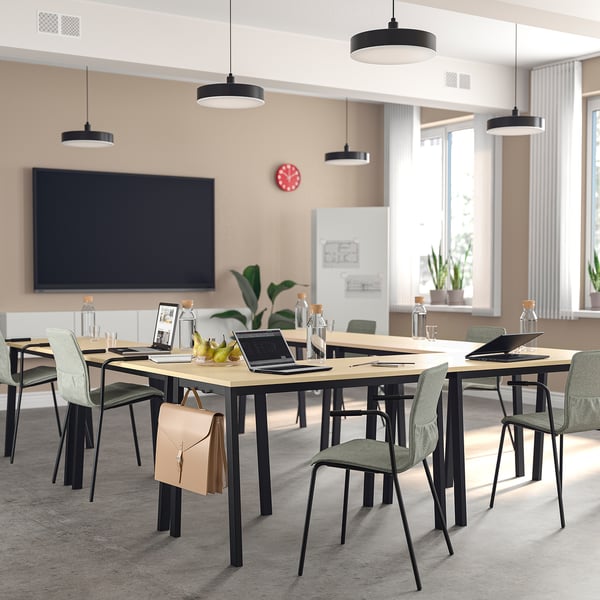 Modern conference room with MITTZON tables in light wood and black chairs, surrounded by large windows.
