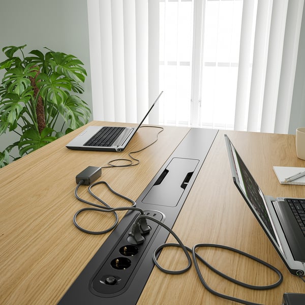 Modern conference table with power outlets, sit/stand design, efficient workspace.