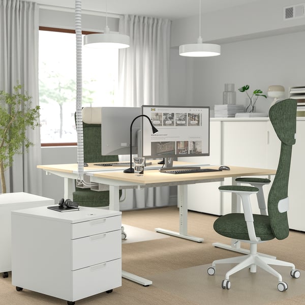 Modern minimalist office with adjustable white MITTZON desk, green ergonomic chair, and cable management tray for productivity and comfort.