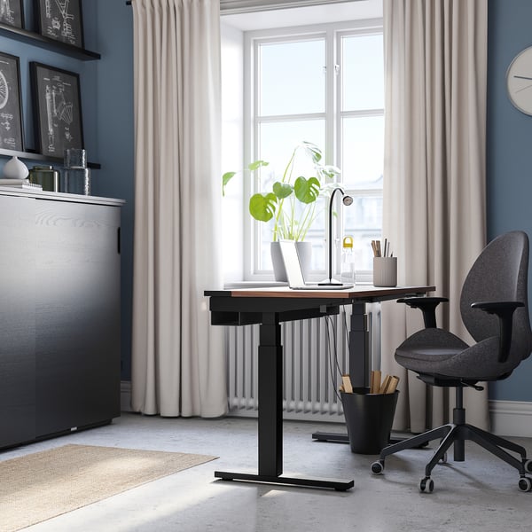 Modern office with MITTZON desk, ergonomic chair, plants, and decor. Desk is black, large, height-adjustable.