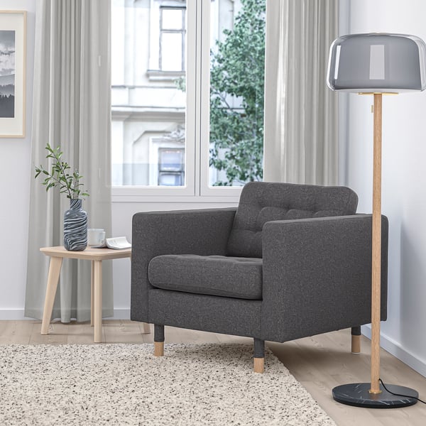 Modern living room: grey MORABO chair, floor lamp, side table, plant, large window. Cosy, stylish.