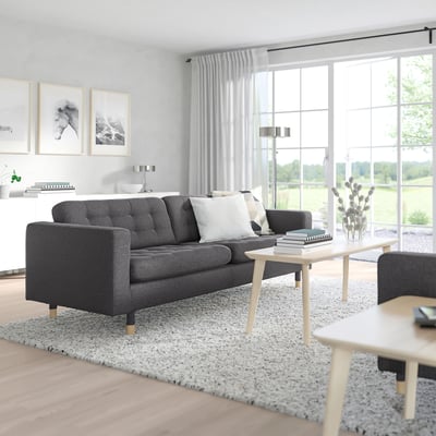 Modern living room: grey MORABO sofa, white coffee table, large windows, bright & airy.