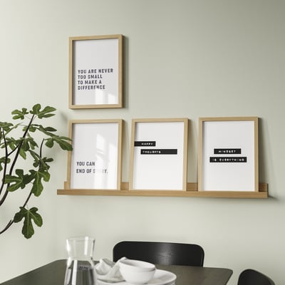 Modern wall-mounted shelf displays four motivational framed prints and a potted plant, providing both decoration and inspiration.