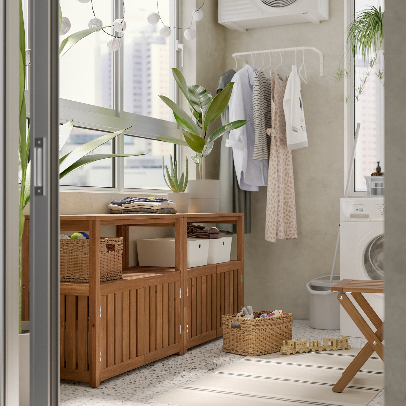 Modern laundry room with wooden NÄMMARÖ storage, white washer, clothes rack, plants, and toys.