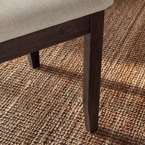 Sofa detail: modern, sturdy dark wood leg supporting comfortable cushioned seat.