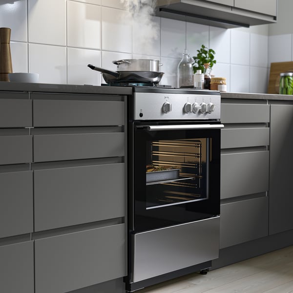 Modern kitchen with stainless steel oven and dark grey cabinets.