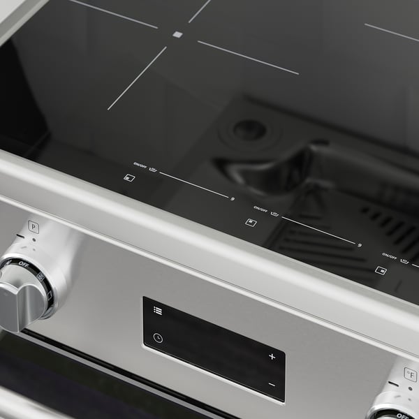 Modern stainless steel cooktop with digital display and integrated knobs. Sleek, black glass surfaces and silver accents.