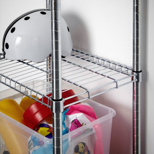 Clear plastic storage bins filled with colourful toys sit on lower shelves of a chrome wire rack. A white helmet rests on the upper shelf.