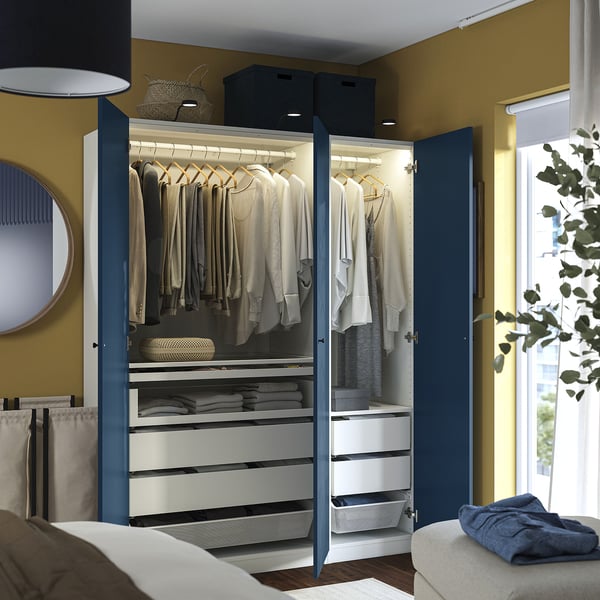 Blue PAX wardrobe with hangers, clothes, drawers, and lights.