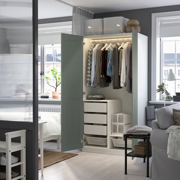 An open wardrobe displaying clothes, with drawers, and lit interior.