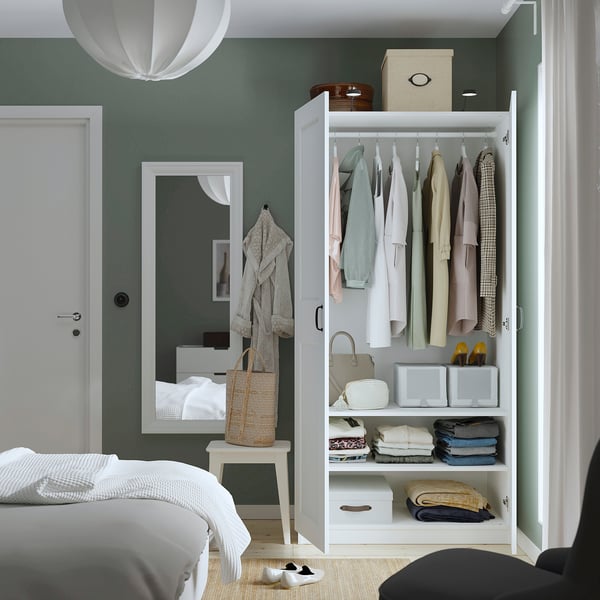 Neatly organised wardrobe with hanging clothes and folded storage, integrated shelves and lighting.
