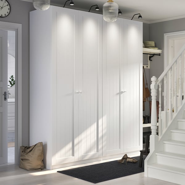 Modern entry with tall white PAX closets beside staircase. Grey walls, black mat, hanging hats.