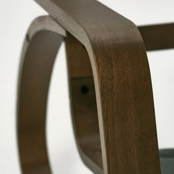 Dark wooden chair leg bend, polished smooth for comfort.