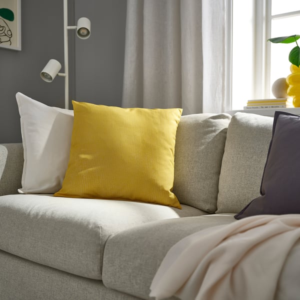 Yellow PROFETBLOMMA cushion on sofa, rectangular, textured fabric, 16x16.