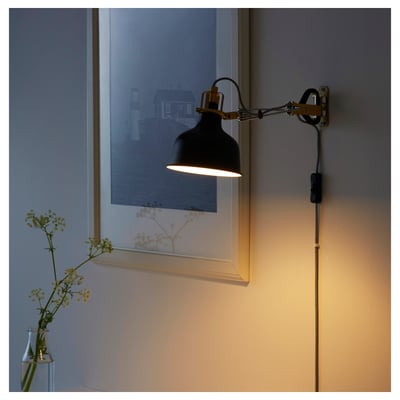 A wall-mounted lamp, RANARP, with an adjustable neck casts warm light. The flexible design directs light where needed.