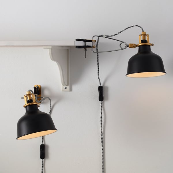 Two adjustable black wall lamps with brass accents and cloth-covered cords. Lamps attach to brackets, allowing directional lighting.