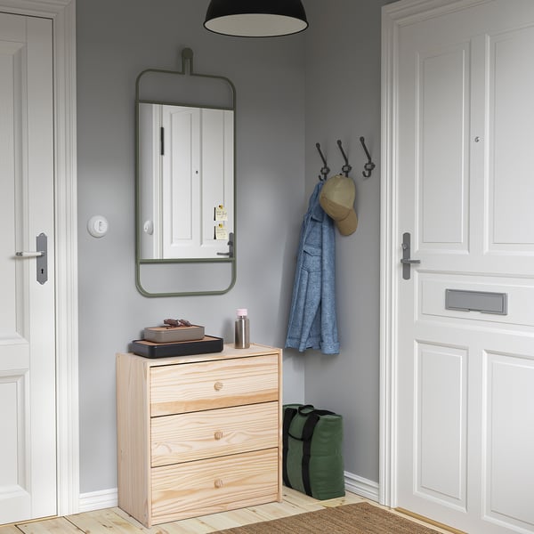 Small wooden RAST chest fits neatly between doors. Light wood, three drawers, modern design.