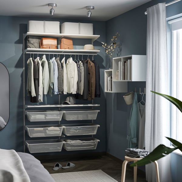 Small, modern white spotlight, RÖKFRI, illuminating clothes on shelves.