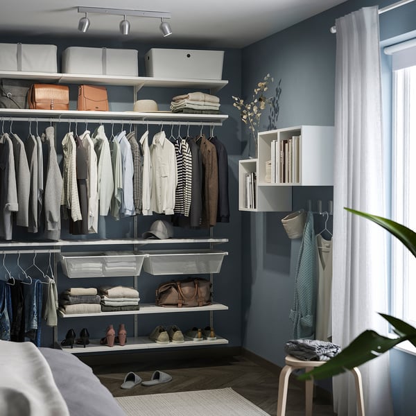 Modern closet with blue walls, white shelves, clothes, and RÖKFRI ceiling spotlight.