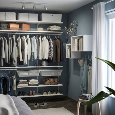 Modern closet with blue walls, white shelves, clothes, and RÖKFRI ceiling spotlight.