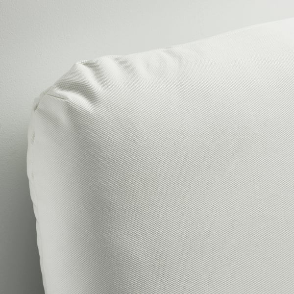 Close-up of a white, fabric-covered bed frame pillow. Soft, textured, inviting.