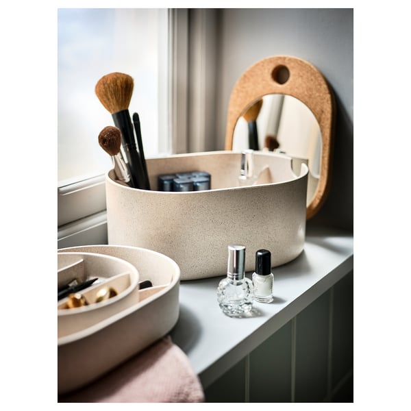 White oval cork organiser on counter with makeup brushes, nail items, and perfume bottle. Mini mirror inside, perfect for small items.