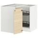 A white corner base cabinet with an open door from IKEAs SEKTION kitchen system. It a light ash wood-patterned door and two black shelves inside.