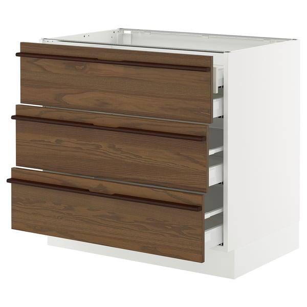 SEKTION kitchen unit in dark brown. Three wooden drawers with handles on a white cabinet. Modern and minimalist design.