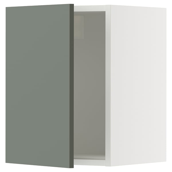 A grey-green ikea SEKTION kitchen cabinet with a white interior and partly open door.