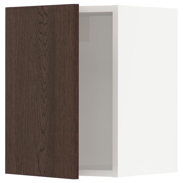 An open dark brown wooden kitchen cabinet door from the SEKTION system by IKEA.