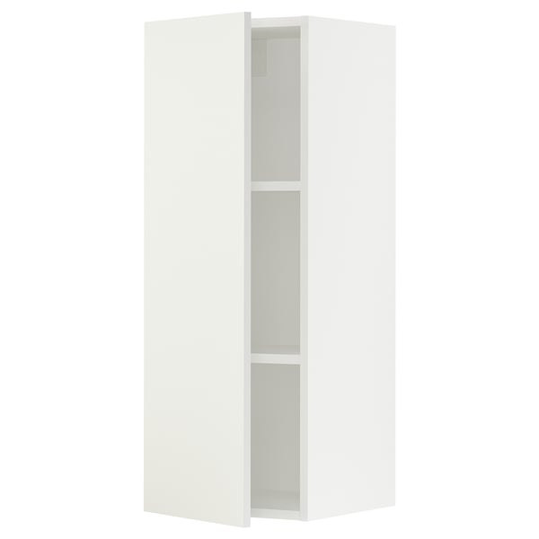 A white SEKTION kitchen cabinet with one open door, revealing two shelves.