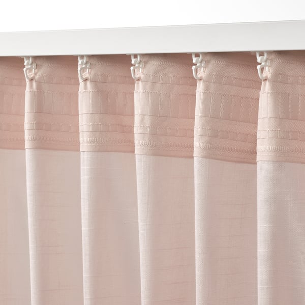 Pink sheer curtains hang from hooks, filtering light, with linen texture. Heading tape and gliders visible at top.